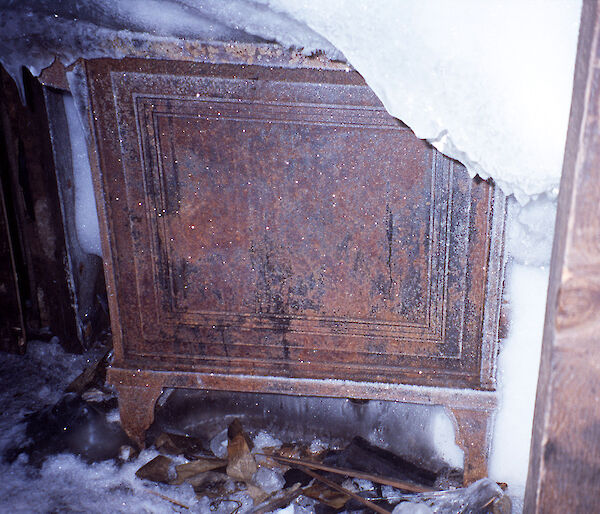 One side of the stove in Mawson's main hut is visible through ice and other detritus, when uncovered in 2002.