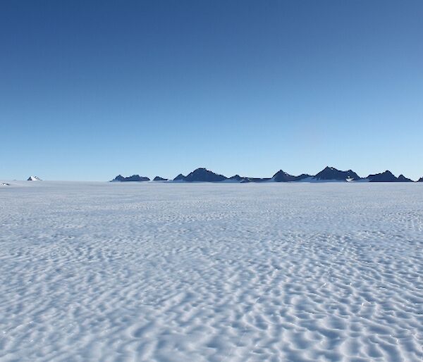 Featureless Ice Plateau with mountain range in distance