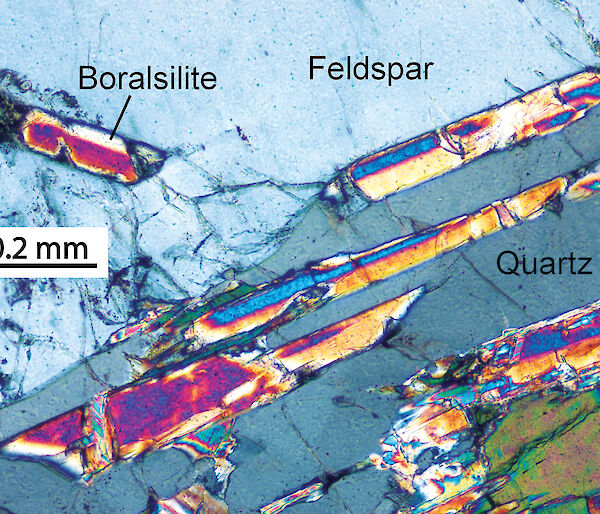 A photomicrograph of brightly coloured crystals of boralsilite