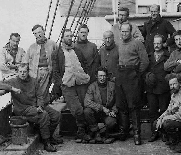 Very old photograph of a group of thirteen men on a ship