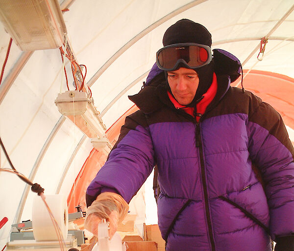Scientist inspects an ice core in a field drill tent