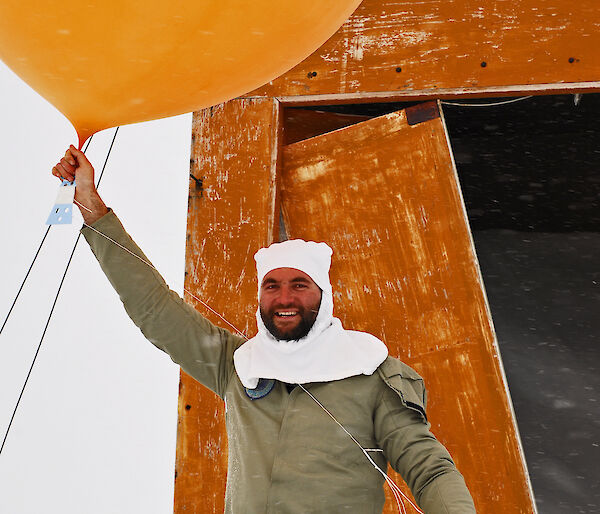 Weather observer holding helium-filled weather balloon
