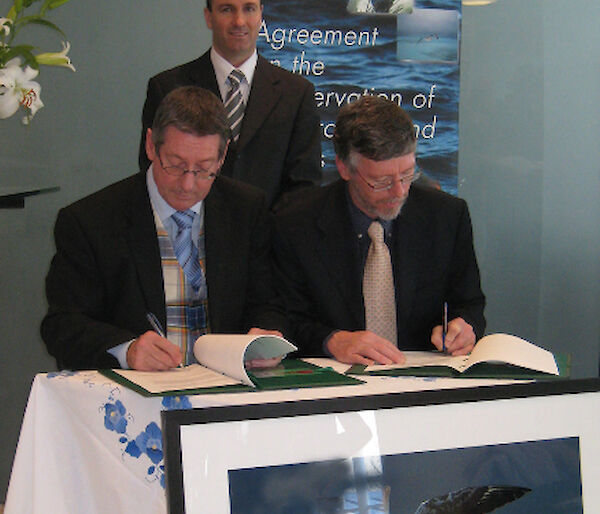 Dr Tony Press, Director of the AAD, and Warren Papworth, ACAP Executive Secretary, sign the headquarters agreement (Director of Antarctic Tasmania, Ben Galbraith standing)