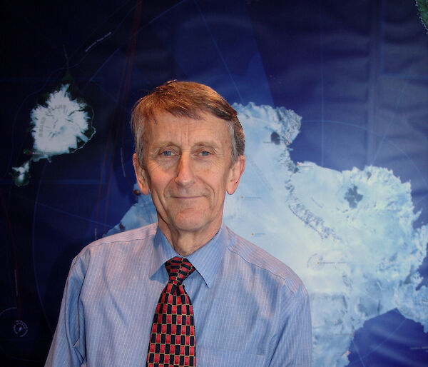 Chief Scientist, Professor Michael Stoddart, poses in front of map of Antarctica