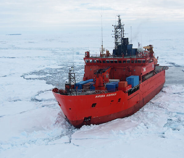 Aerial view of the ship Aurora Australis surrounded by icy and water.