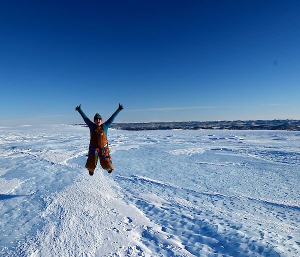 Woman jumping for joy in icy landscape