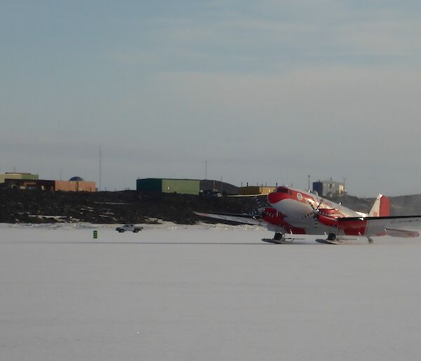 The Basler DC 3 landing on the sea ice with Davis station in the background.