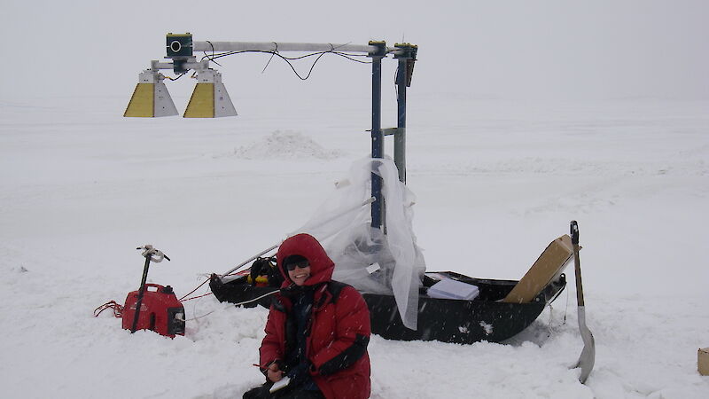 Expeditioner measuring snow thickness on sea ice in front of Davis station using sled-based radar.