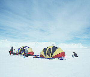 An older image of tourists setting up tents on the ice in Antarctica.