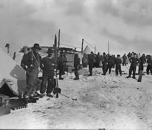 A black and white photograph of people and tents on the sea ice.