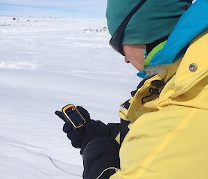 Expeditioner uses GPS in the field with snow all around