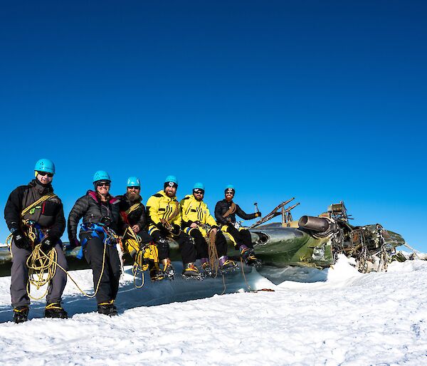 Expeditioners sitting on wing of aircraft remains