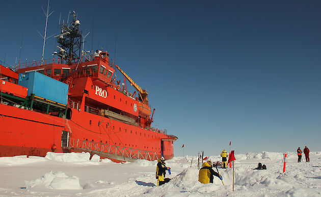 Scientists collecting samples on the sea ice, beside the Aurora Australis.