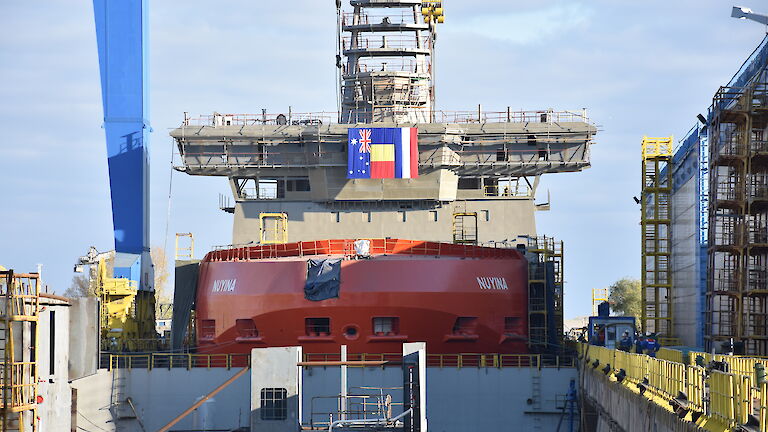 The Nuyina in the wet dock crowned with a crows nest, 32 metre-long navigation bridge and science observation deck.