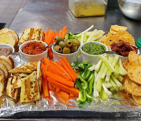 A delicious, healthy platter of carrot sticks, celery, crackers and dips bound for the bar
