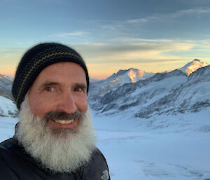 Self portrait of a man in front of a snowy mountain landscape