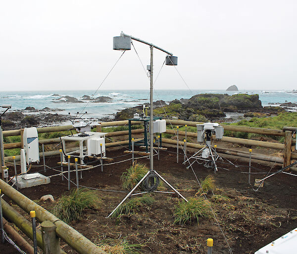 Atmospheric instruments inside a wooden fence on Macquarie Island.