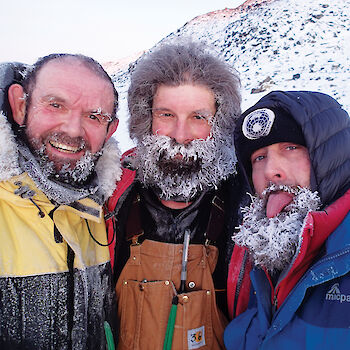 Three expeditioners posing with ice crystals in their beards.