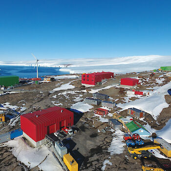 Low aerial view over Mawson station buildings.