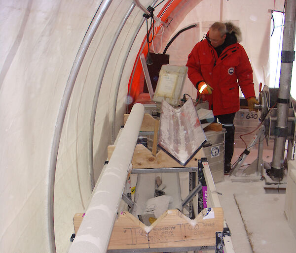 Scientist inside a large cylindrical tent with an ice core.