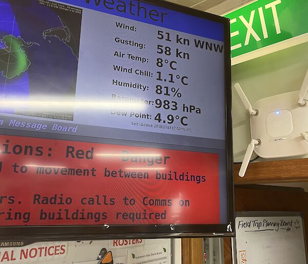 An electronic sign on a wall displays the current weather conditions