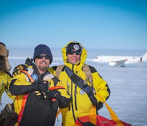 three expeditioners taking a final photograph in front of the plane