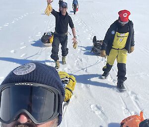 five expeditioners drag gear on sleds