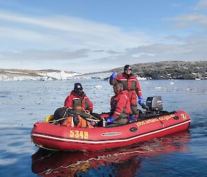 Ron and two others, dressed in immerison suits in an IRB, water and shoreline in the background