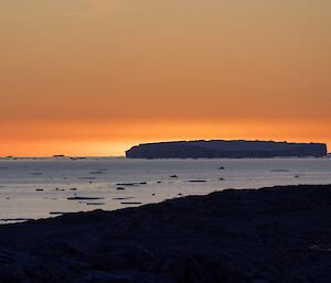 Orange sunset over an iceberg