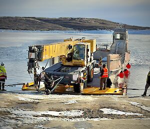 A crane being positioned on a Nuyina barge at Mawson wharf, destined for return by Nuyina to Australia