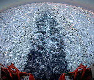 A fish-eye lens view of the back of the Nuyina leaving a trail in the pack ice