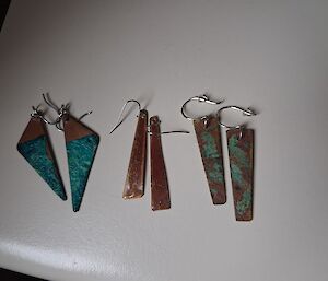 3 sets of copper earrings of different shapes each a blend of copper colour and green patina.
