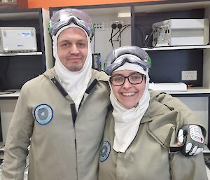 Two Bureau of Meteorology expeditioners in the office dressed in their PPE, ready to do a balloon release at Mawson.