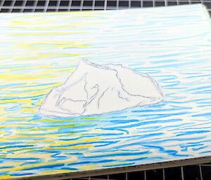 An image of a piece of art, showing an iceberg in blue water, with the sparkle of golden sunset down one side.