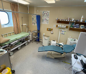 A room within the medical facility with a dentist's chair, mobile bed and various medical equipment