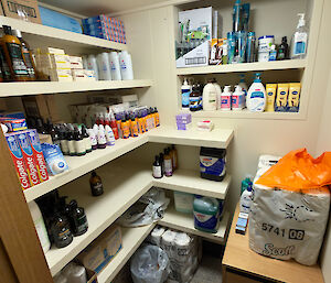 a small room stocked with various personal toiletry items and cleaning stores on shelves