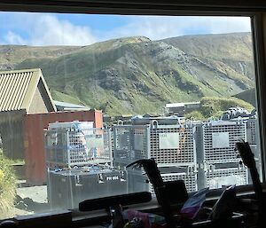 The same image as Image 1 but the sun is out and there is blue sky over the rugged green plateau.