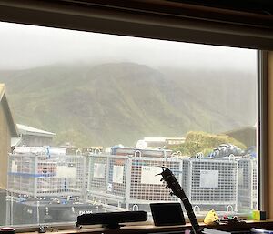 The same image as Image 1 with thick mist over the rugged green plateau.