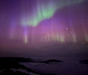 Shimmers of green purple and pink in the night sky