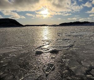 Slushy ice on the sea under a blue sky with clouds
