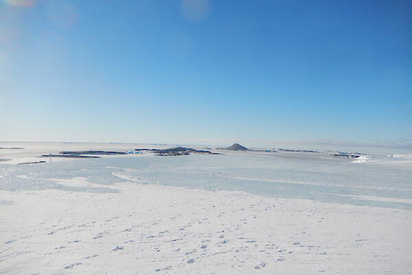 a picture of a blue ice plateau, overlooking Mawson Station with sea ice and islands in the background