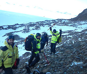 four expeditioners on a rocky feature enjoying a hike