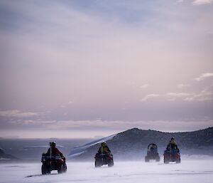 Four quad bikes driving across the ice in Antarctica