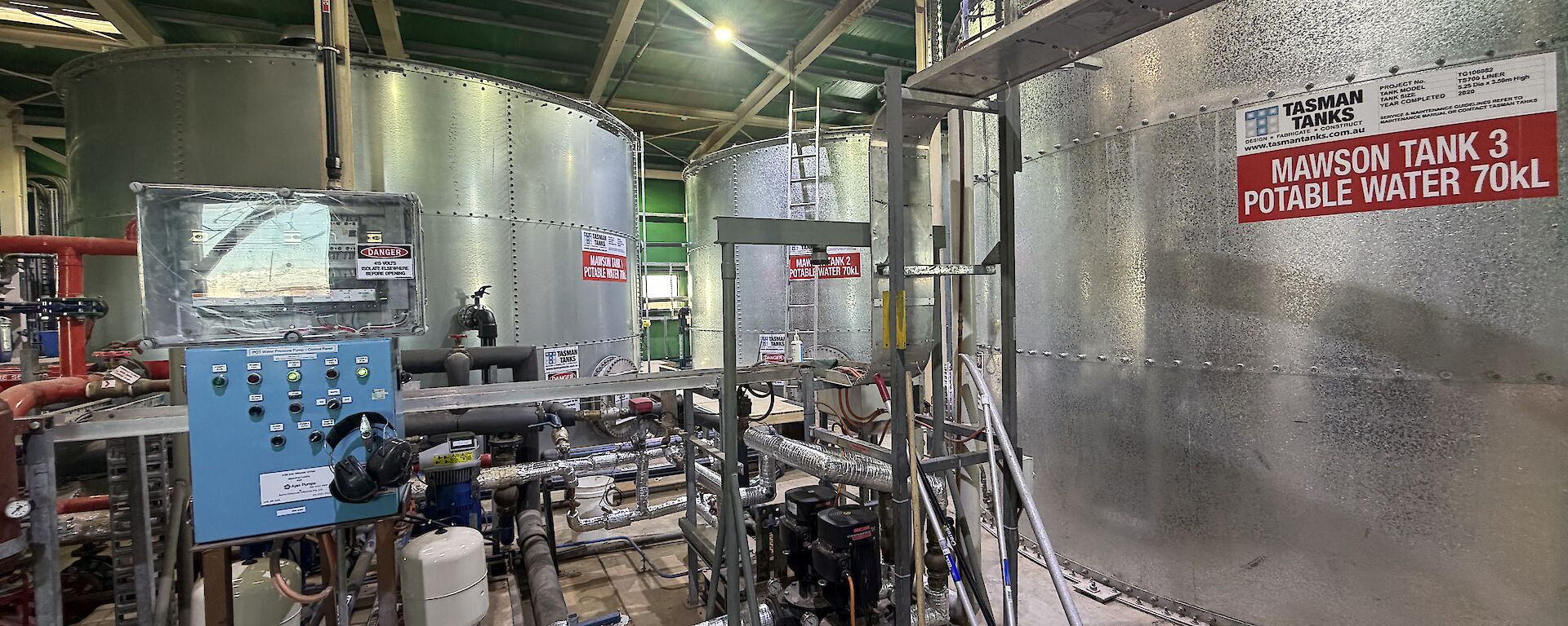 Inside Mawson's tank house, showing 3 x 70,000 litre water tanks, pumps, pipes and control panels.