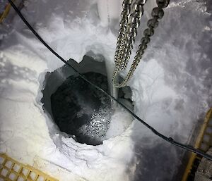 Looking down into the melt lake cavern some 10 metres below while standing on the pontoon bridge