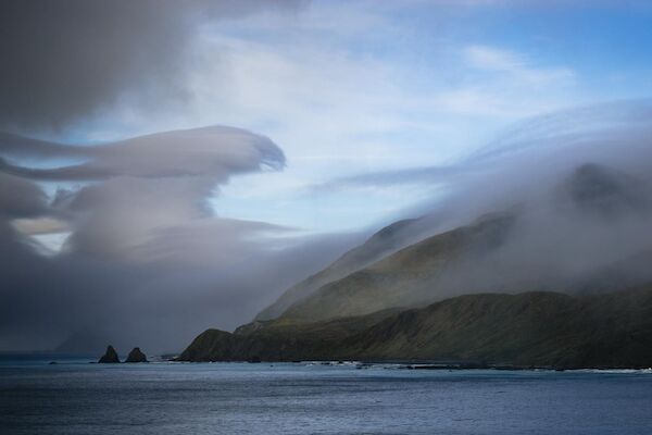 A large cloud bank swirls over the coastal edge of Macqurie Island.