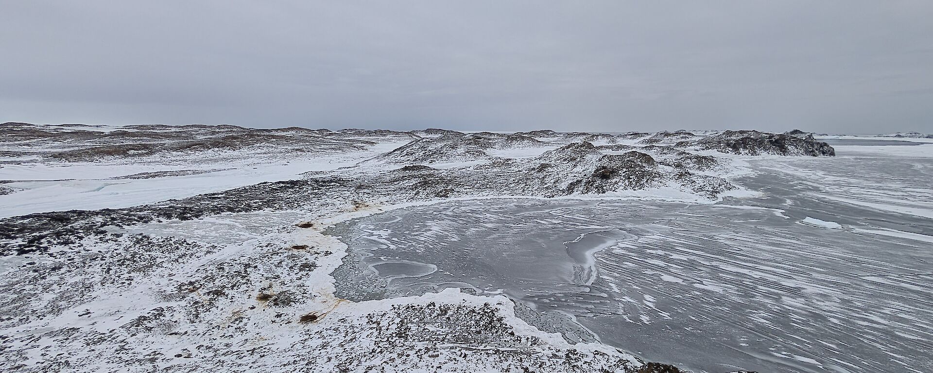 An icy visa with rocks and a frozen lake