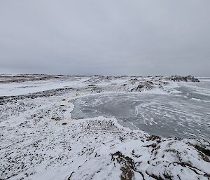 An icy visa with rocks and a frozen lake