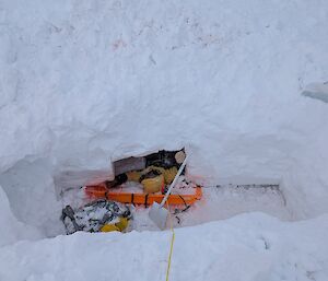 A person on a stretcher down a deep hole in the ice