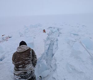 A man digging a hole in the ice